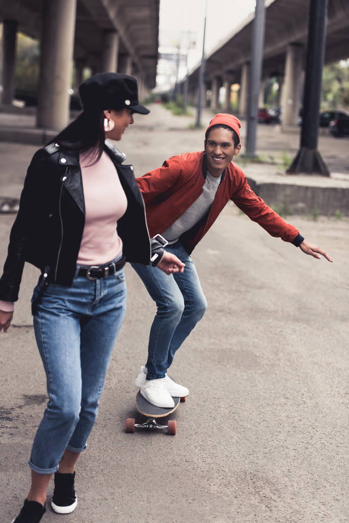 homme équitation à petite amie sur skateboard
 - Photo, image