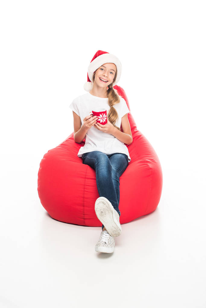 tiener in kerstmuts met koffie - Foto, afbeelding