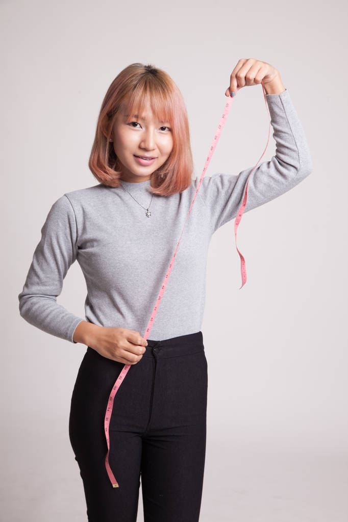 Jovem mulher asiática com fita métrica
. - Foto, Imagem