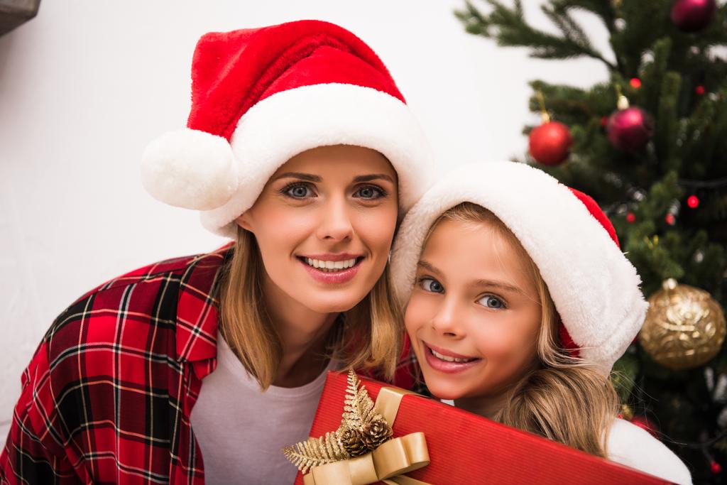 Madre e figlia in cappelli Babbo Natale - Foto, immagini