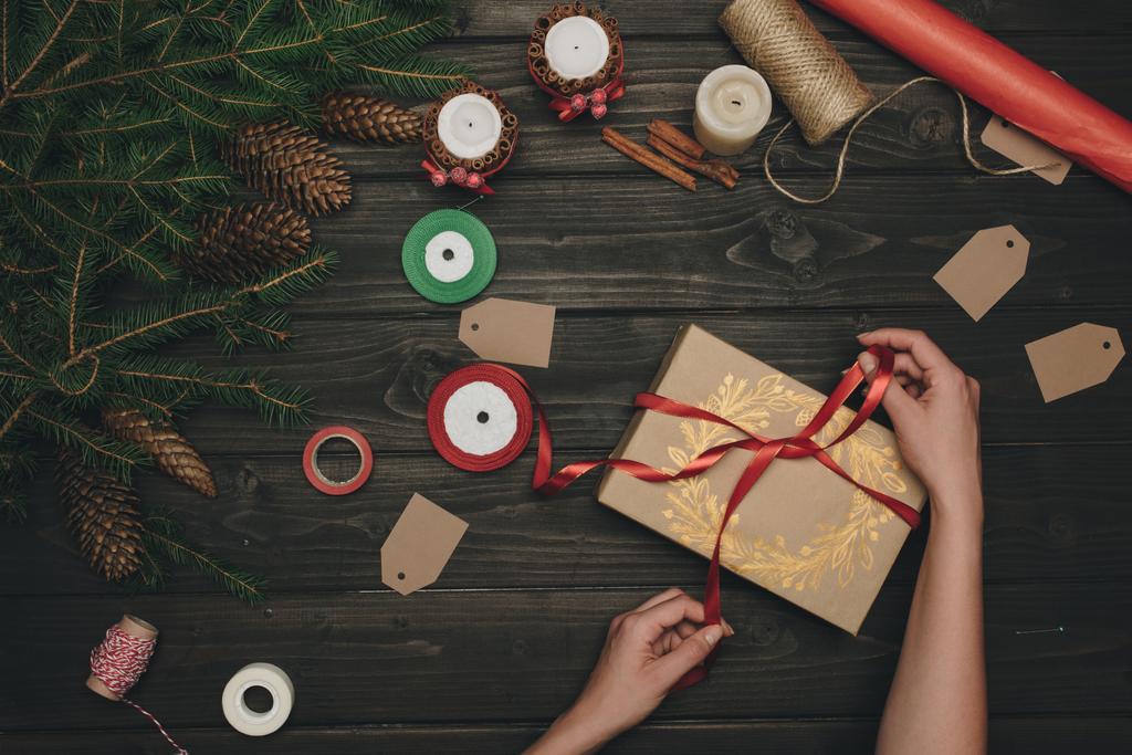 Mujer decorando regalo de Navidad
  - Foto, Imagen