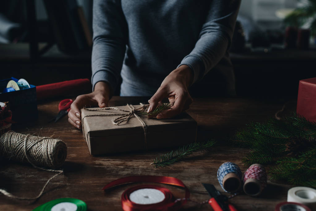 Mujer decorando regalo de Navidad
 - Foto, Imagen