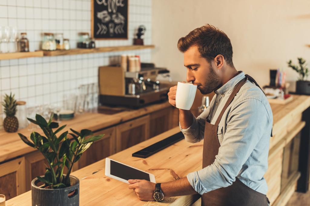 barista with cup of coffee using tablet - Photo, Image