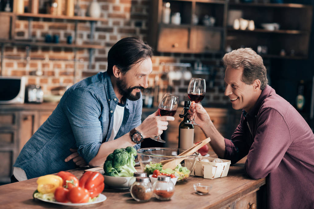 mannen drinken van wijn in de keuken - Foto, afbeelding