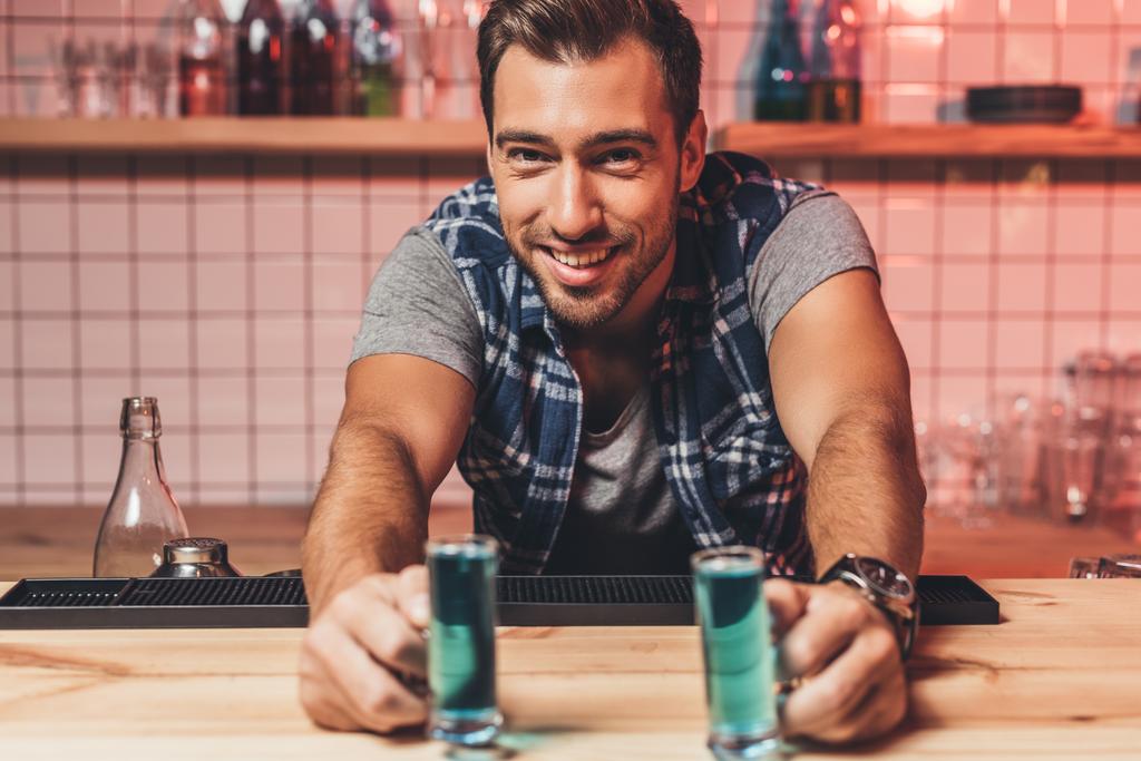 barman with alcohol shots on counter - Photo, Image