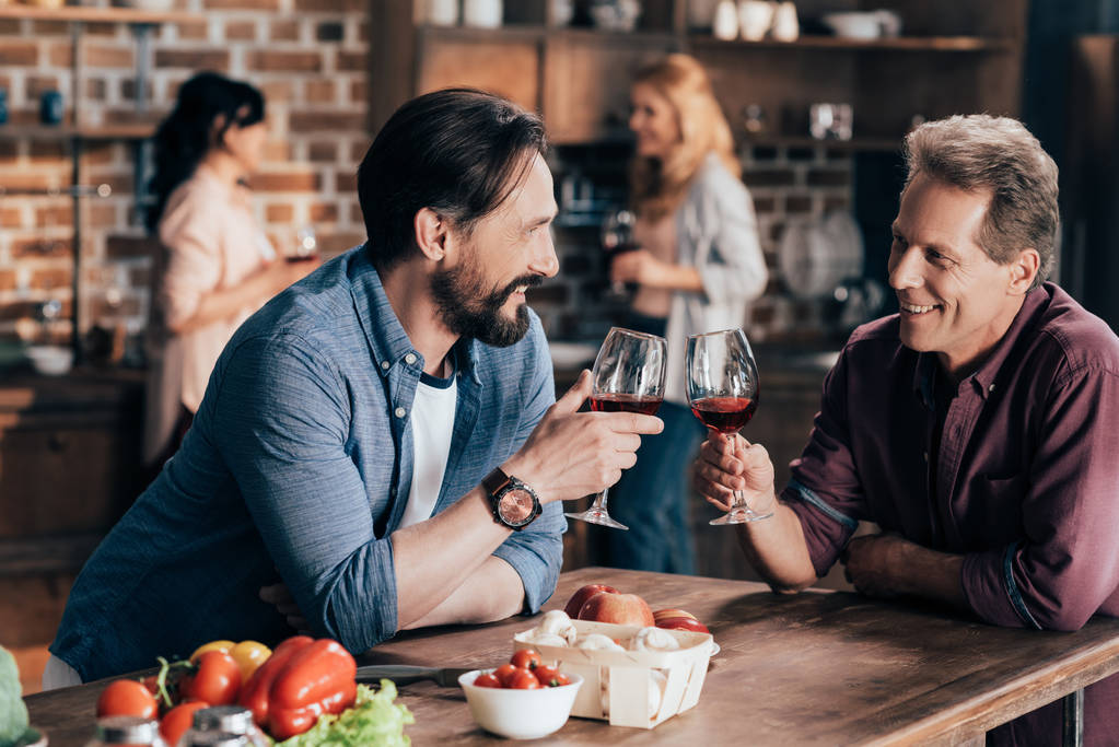 miespuoliset ystävät juomassa viiniä
 - Valokuva, kuva