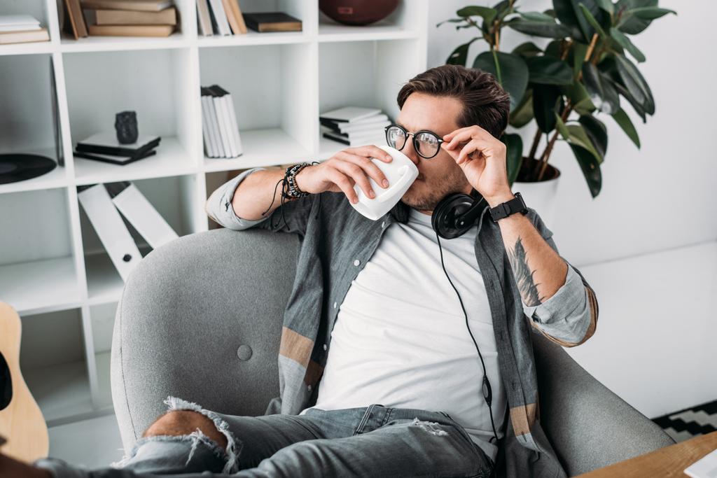Mann mit Kopfhörer trinkt Kaffee - Foto, Bild
