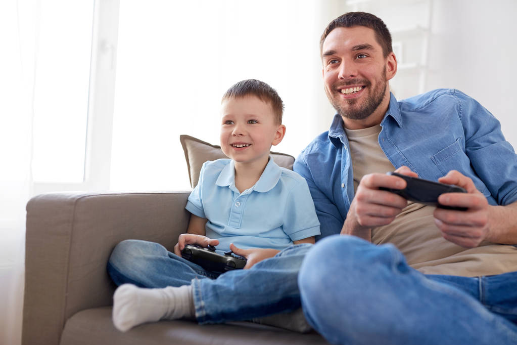 батько і син грають у відеогру вдома
 - Фото, зображення
