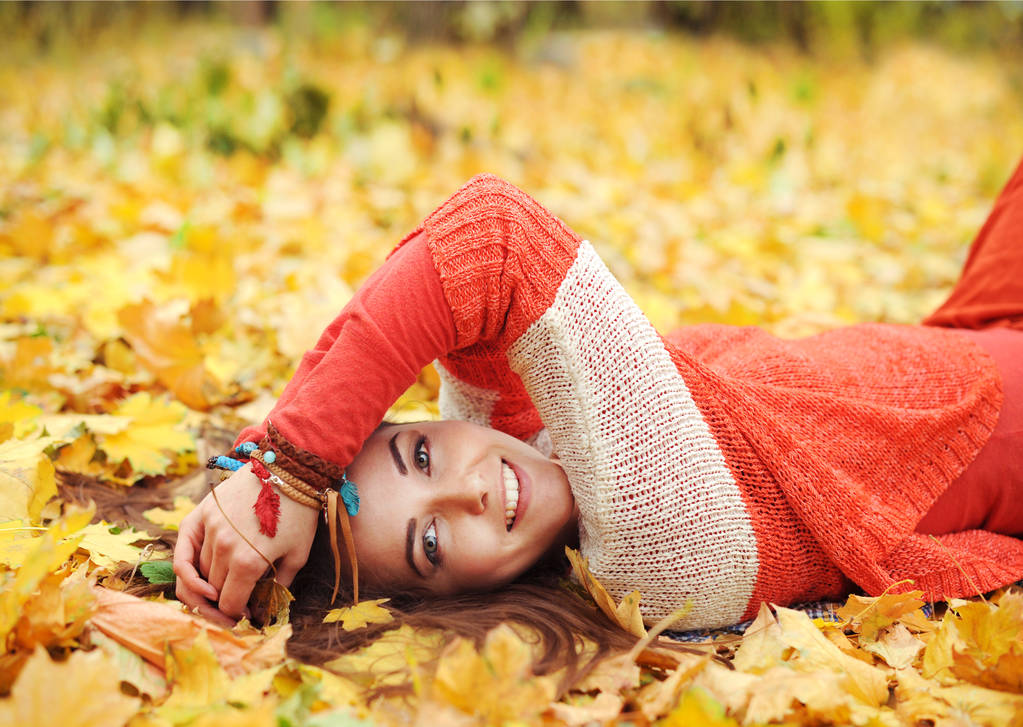 Ładna kobieta yound odpocząć leżącego w jesienny park - Zdjęcie, obraz