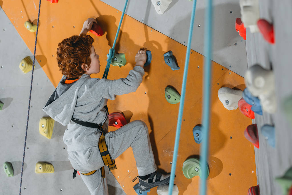 Little boy climbing wall with grips - Photo, Image