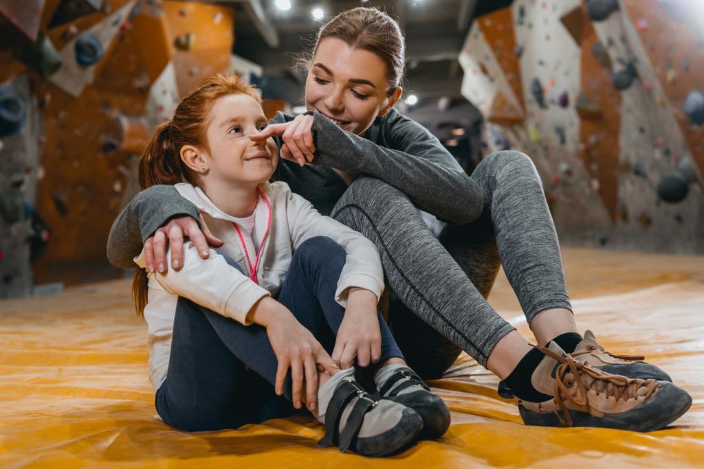 Girl and mom hugging on mat at gym  - Photo, Image