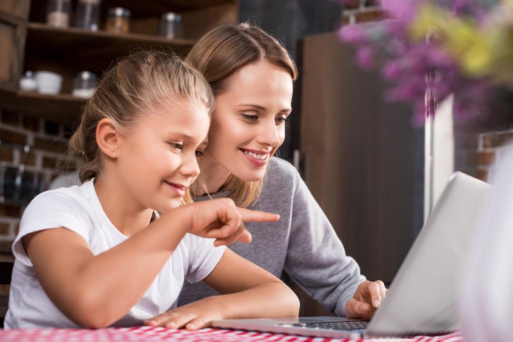 Äiti ja tytär käyttävät kannettavaa tietokonetta - Valokuva, kuva