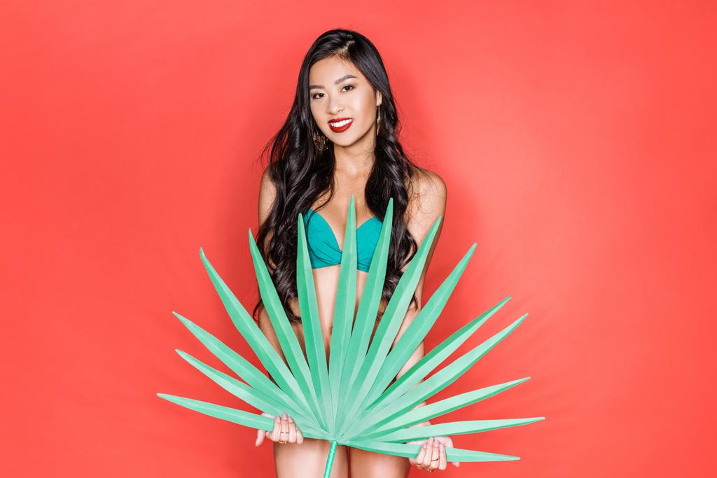 woman in swimsuit holding palm leaf - Photo, Image