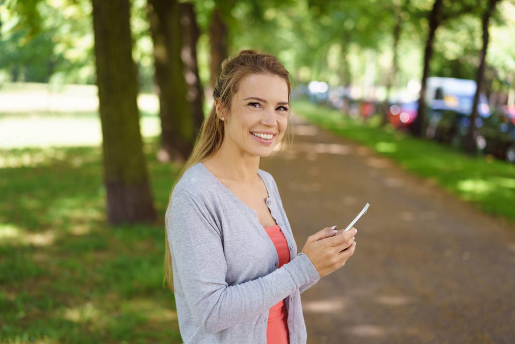 Usměvavá mladá žena ve stinném parku - Fotografie, Obrázek