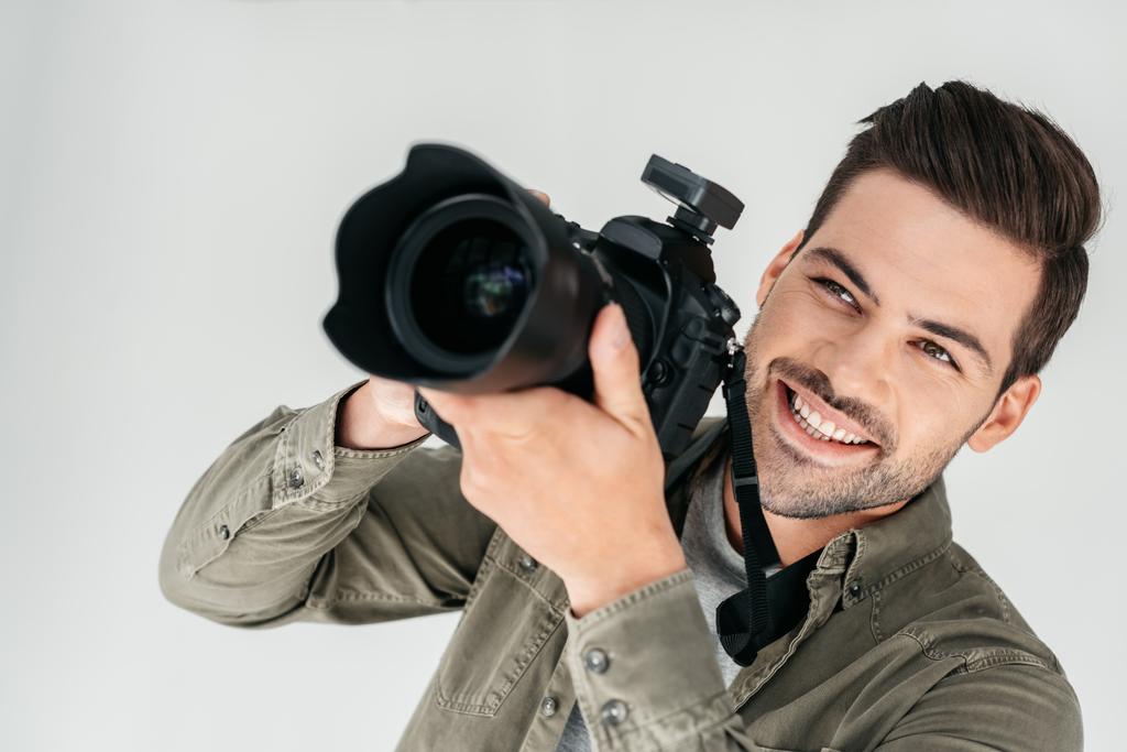 Lachende fotograaf met een digitale camera - Foto, afbeelding