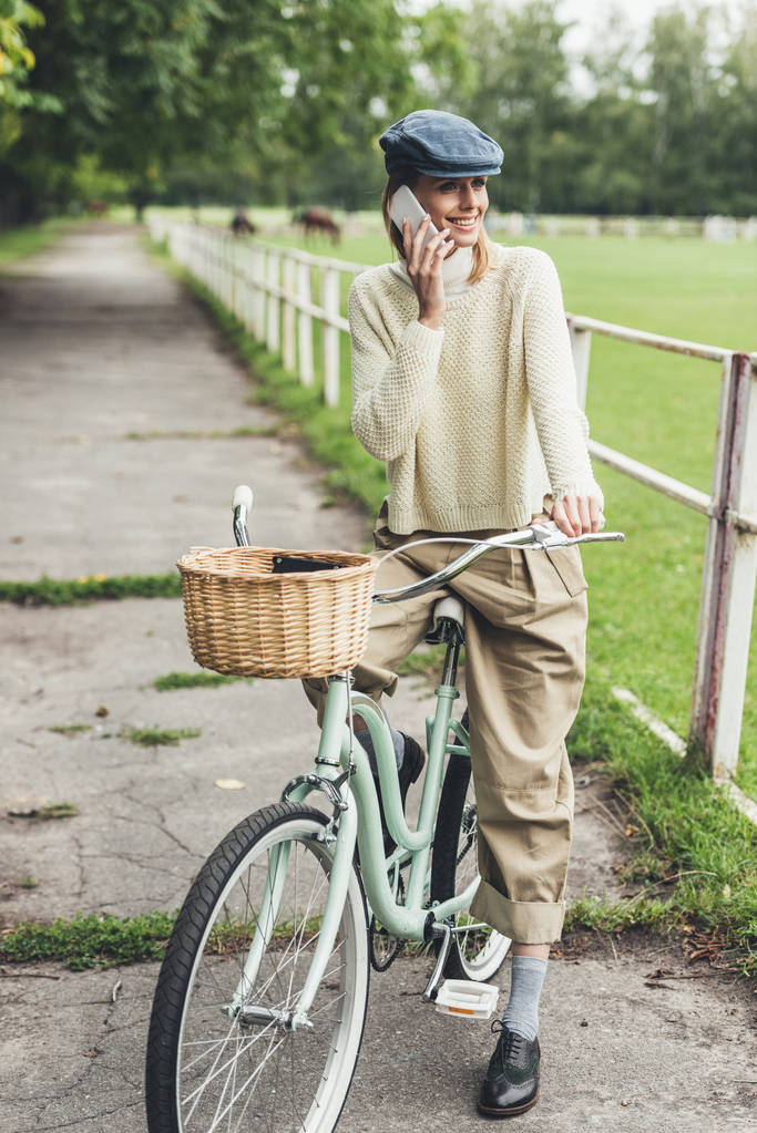 自転車にスマート フォンを持つ女性  - 写真・画像