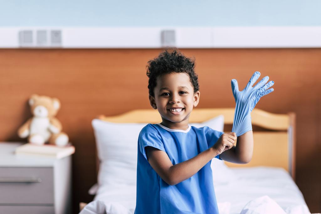 Afrikanischer amerikanischer Junge trägt medizinische Handschuhe - Foto, Bild
