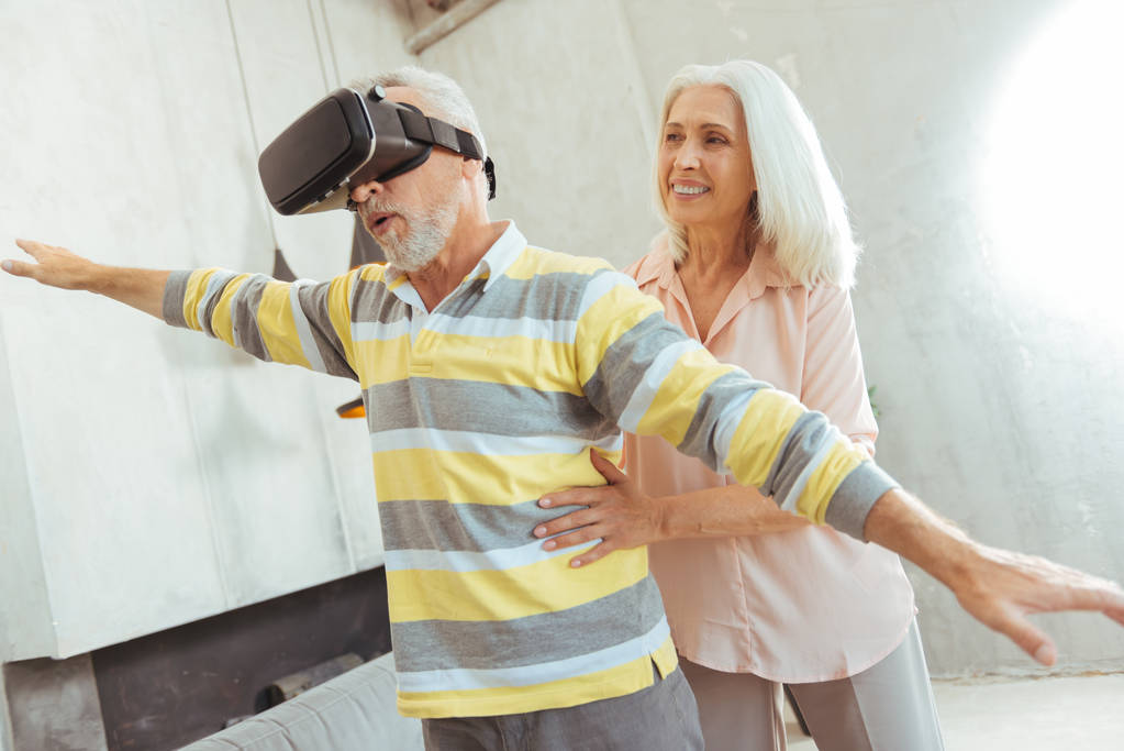 Приятный пожилой мужчина испытывает VR очки со своей любящей женой
 - Фото, изображение