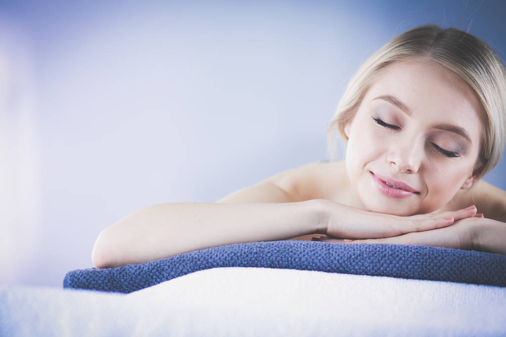 Fiatal nő fekszik egy masszázsasztalon, csukott szemmel pihen. Nő. Spa szalon - Fotó, kép