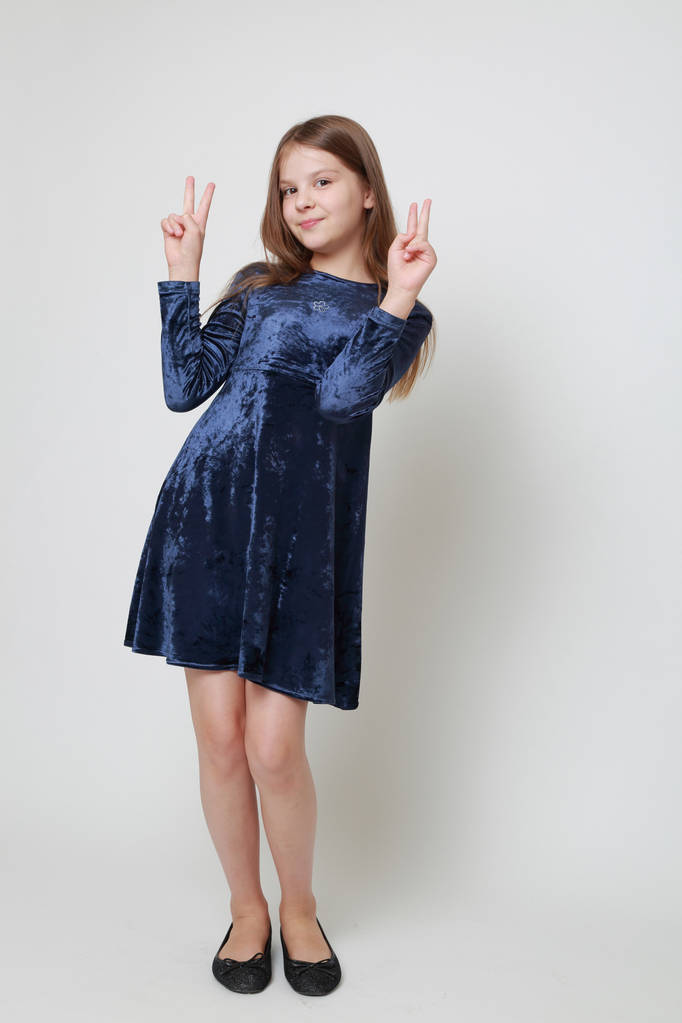 Schitterend tiener meisje in een jurk poseren voor een studio portret - Foto, afbeelding