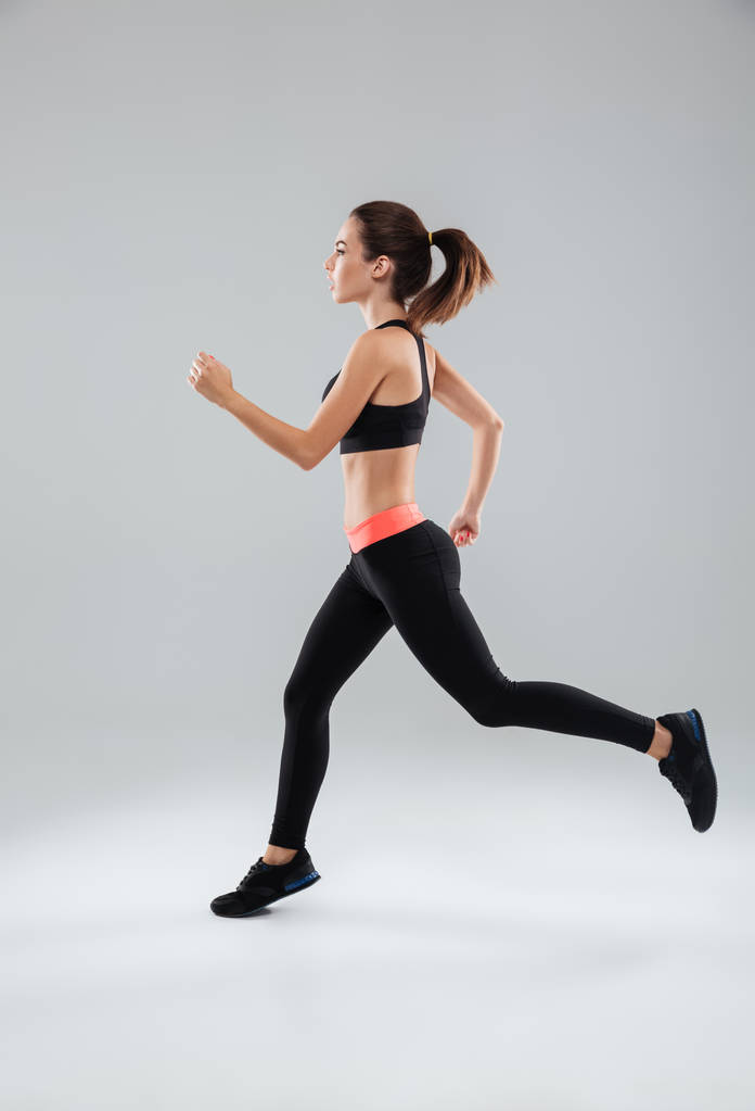 Full length picture of a sports woman running in studio - Photo, Image