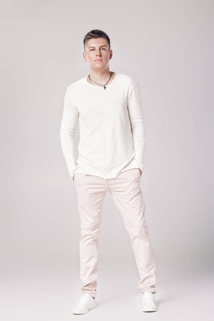 komea nuori mies valkoisessa puserossa ja housuissa
 - Valokuva, kuva