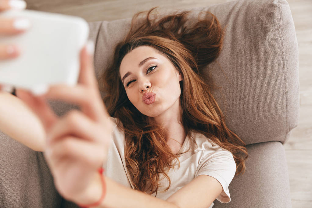 スマート フォンで selfie を作るかわいい若い女性 - 写真・画像