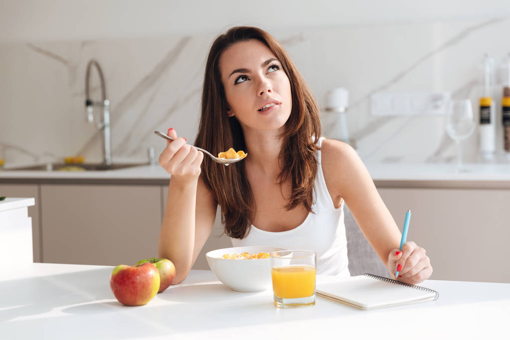 junge nachdenkliche Frau beim Frühstück Müsli - Foto, Bild