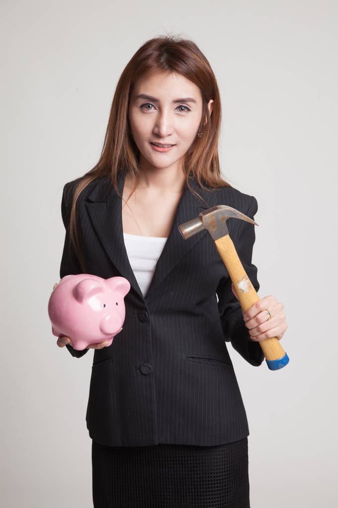 Mujer asiática con banco de monedas de cerdo y martillo
. - Foto, Imagen