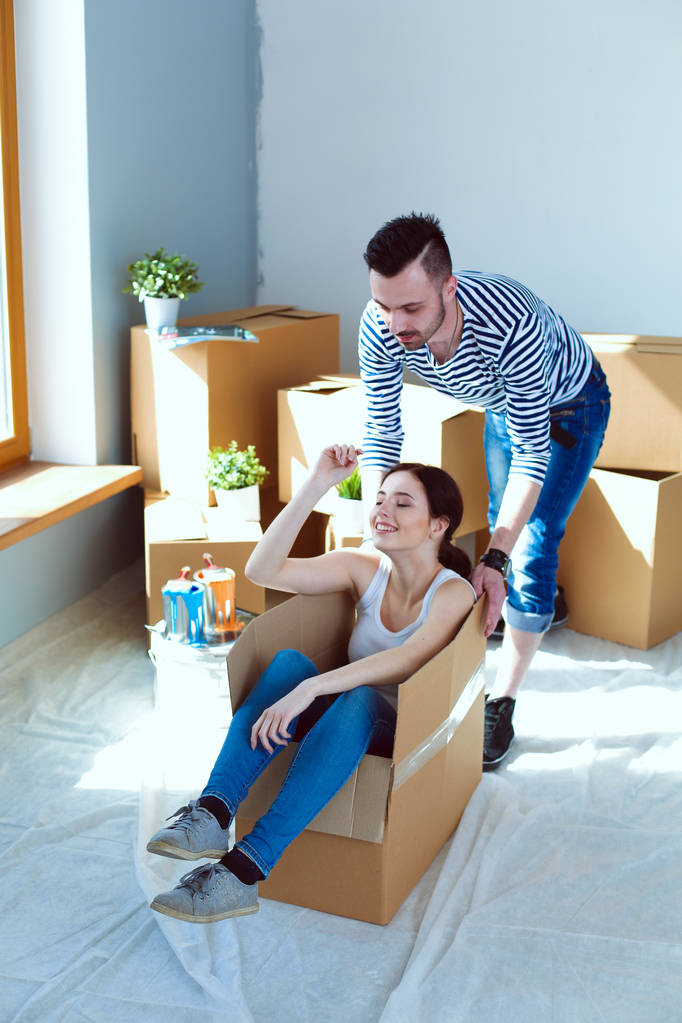 Счастливая молодая пара распаковывает или упаковывает коробки и переезжает в новый дом. молодая пара
 - Фото, изображение