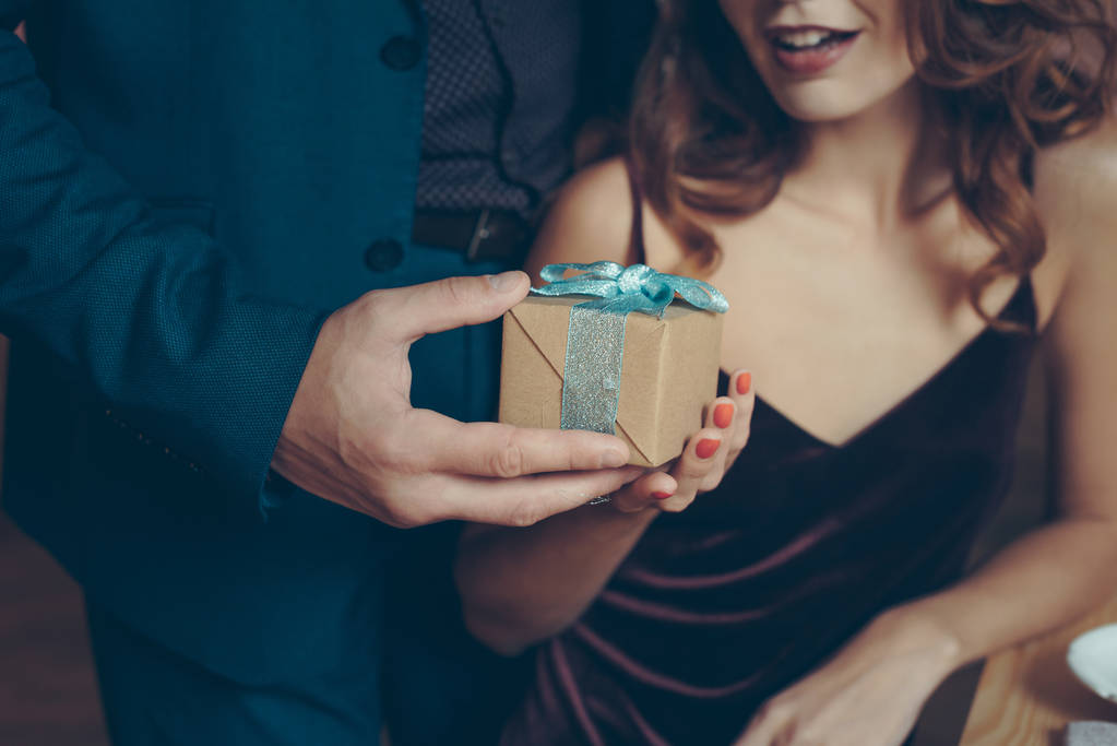 мужчина преподносит подарок девушке
 - Фото, изображение