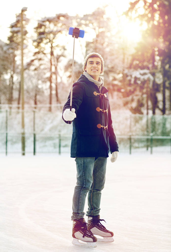 jovem feliz com smartphone na pista de gelo
 - Foto, Imagem