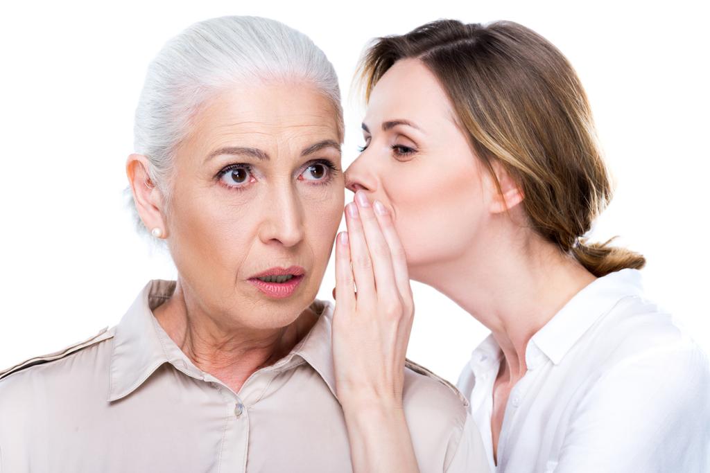adult daughter whispering to senior mother - Photo, Image