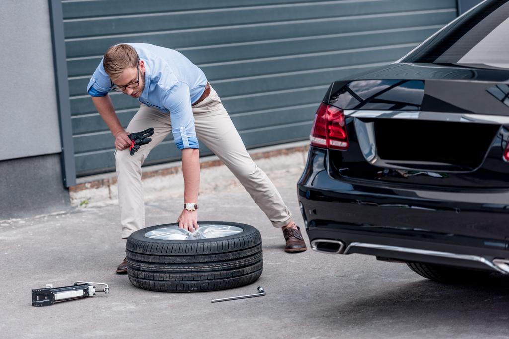 homem mudando pneu do carro
  - Foto, Imagem