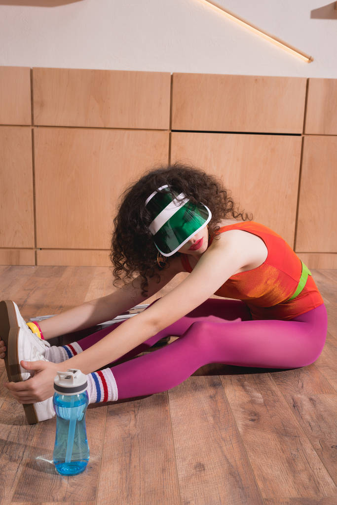 mujer deportiva estirándose en el suelo
 - Foto, Imagen