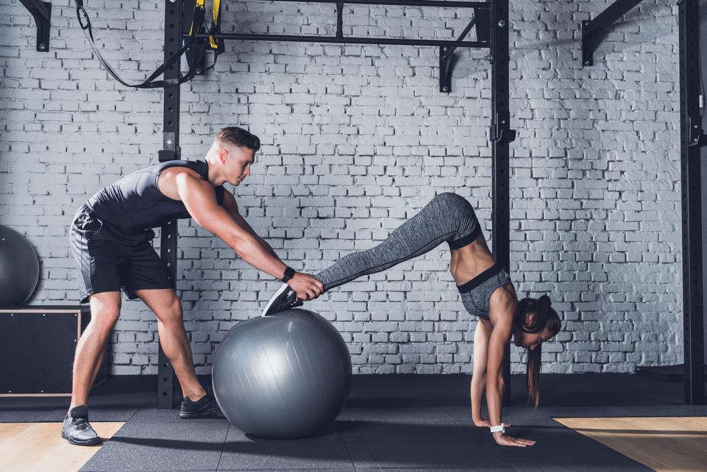 trainer helping woman work out - Photo, Image
