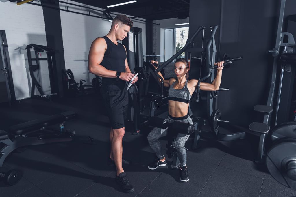 trainer and sportive woman in gym - Photo, Image