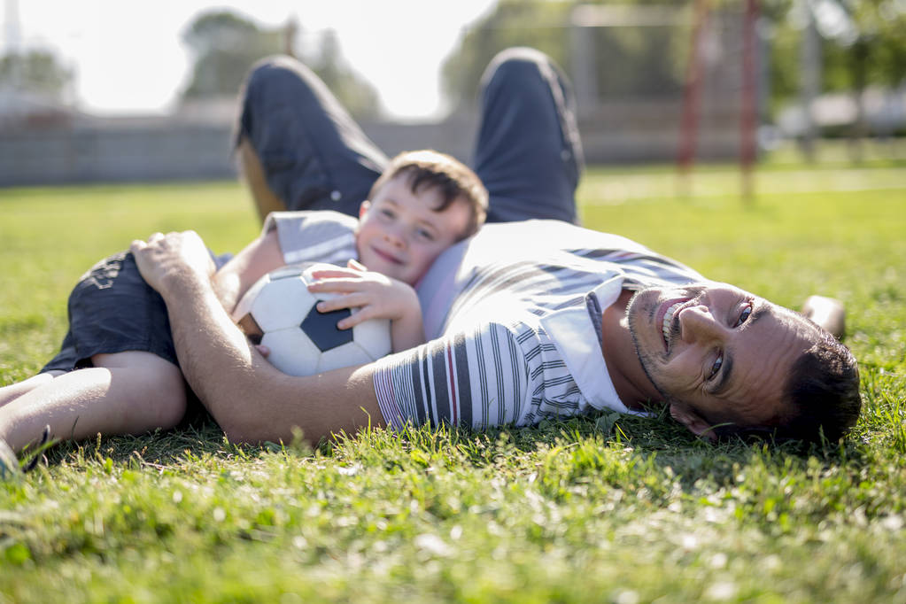 muž s dítětem hrát fotbal na hřišti - Fotografie, Obrázek
