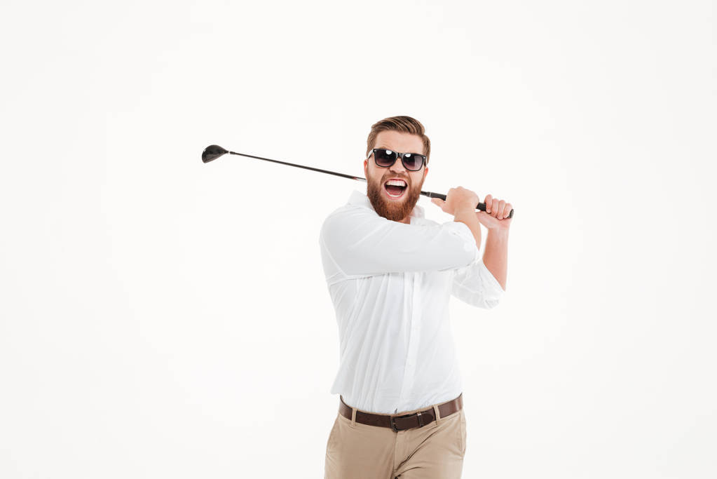 Young screaming emotional bearded man holding golfstick - Photo, Image