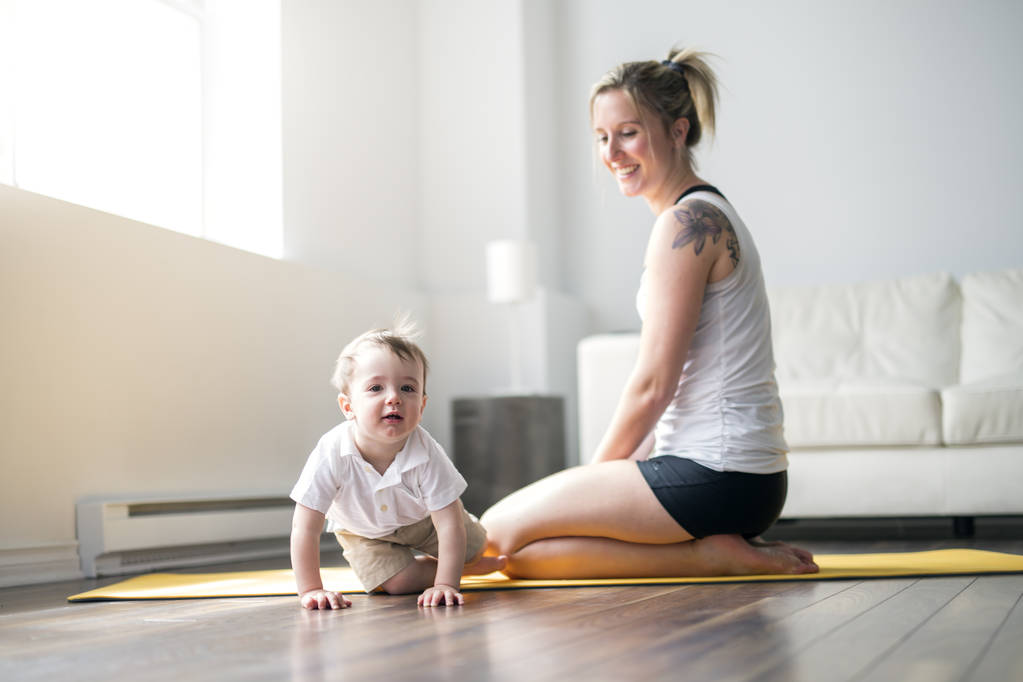 Sportmutter betreibt Fitness und Yoga mit Baby zu Hause - Foto, Bild