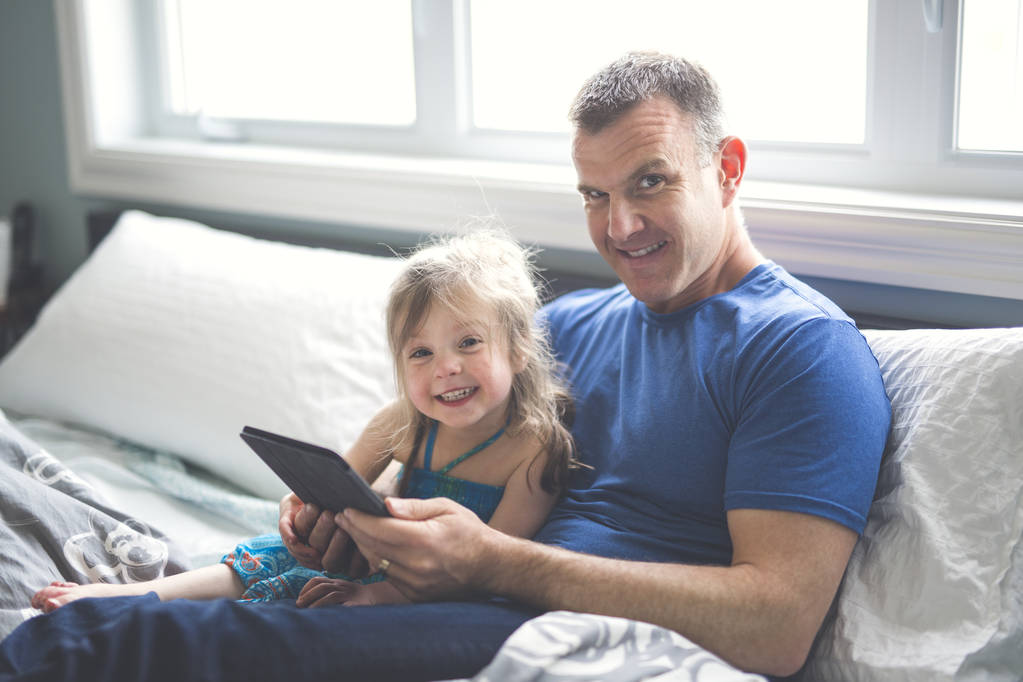 otec a dcera odpočívat v posteli s tabletovým počítačem - Fotografie, Obrázek
