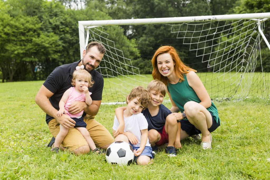 Famille heureuse avec ballon de football sur un terrain
 - Photo, image