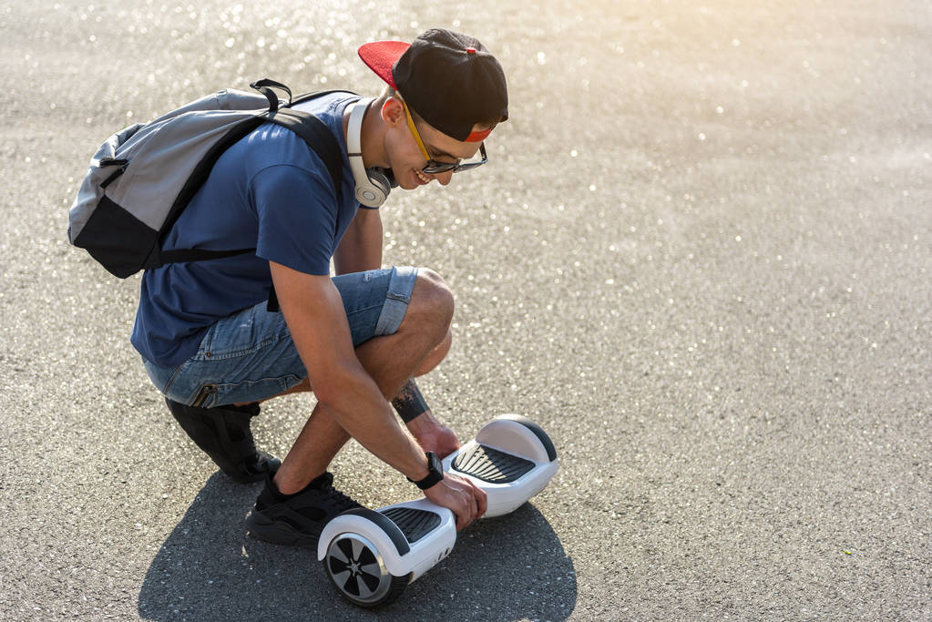 Uitgaande jongeman wandelen met gyroscooter - Foto, afbeelding