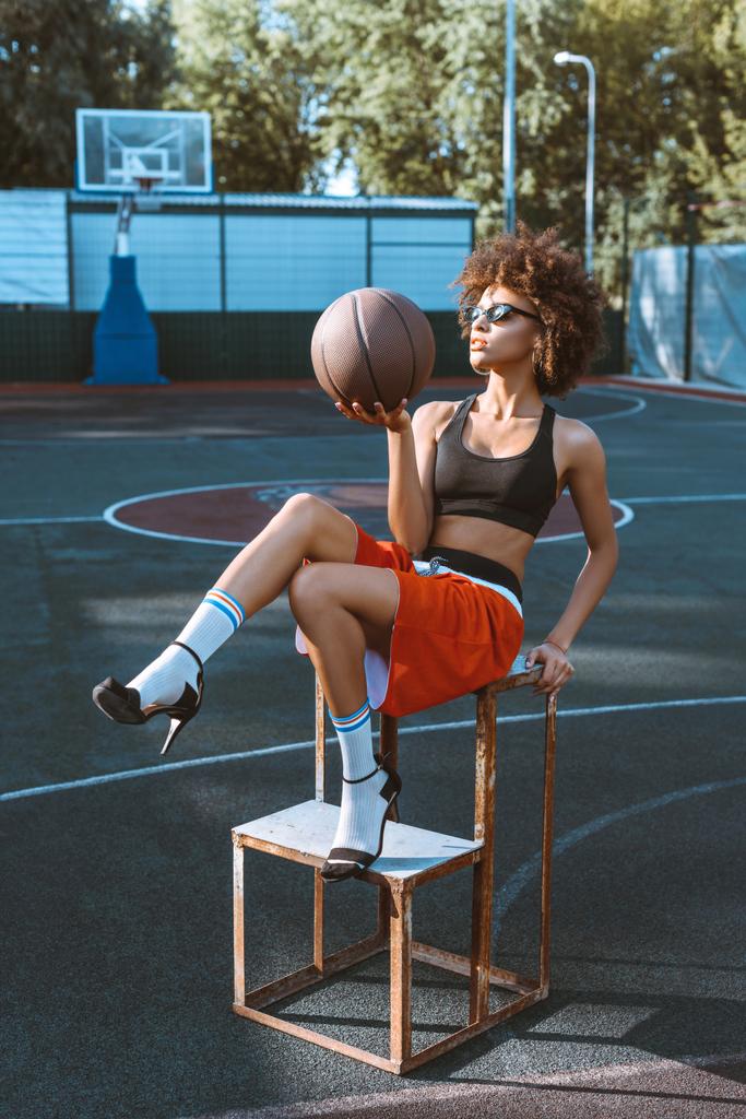 женщина проводит баскетбол на спортивной площадке
 - Фото, изображение