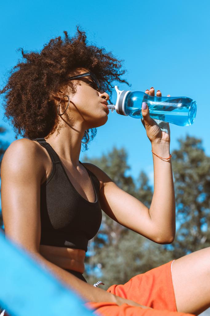 mujer afroamericana bebiendo de la botella de agua
 - Foto, Imagen