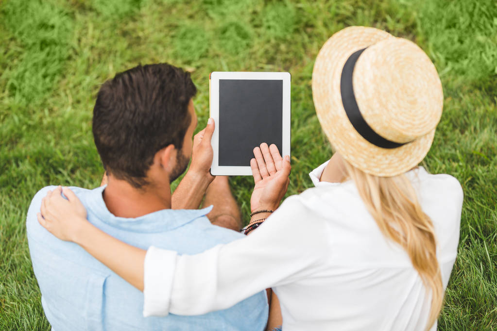 tablet yeşil çim üzerinde çift - Fotoğraf, Görsel