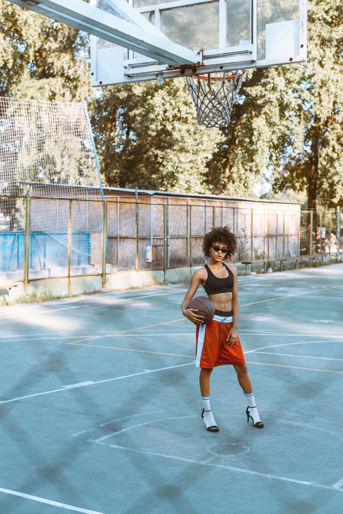 kadın spor giyim ve topuklar üzerinde sportscourt - Fotoğraf, Görsel