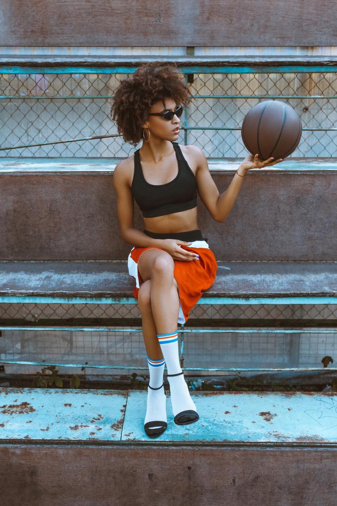femme en vêtements de sport et talons avec basket
 - Photo, image