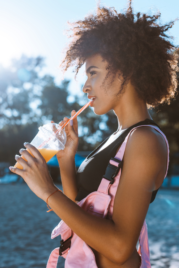 アフリカ系アメリカ人の女性がジュースを飲む - 写真・画像