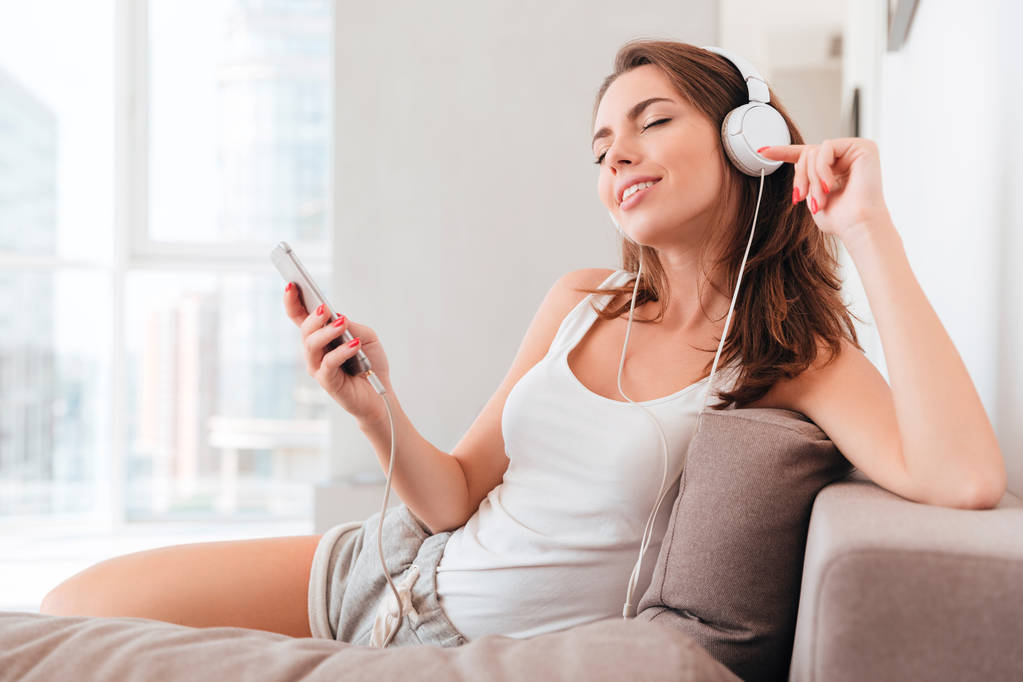 όμορφη νεαρή γυναίκα με ακουστικά ακούγοντας μουσική - Φωτογραφία, εικόνα